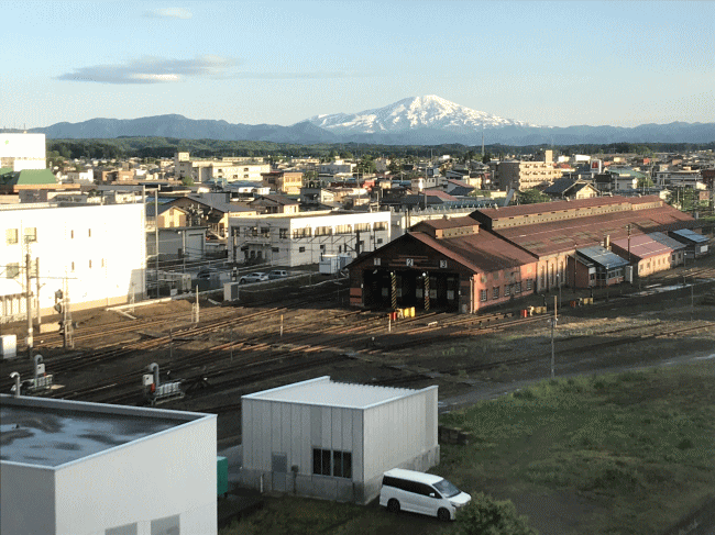 ホテルルートイン新庄駅前から見た新庄駅期間車庫と鳥海山
