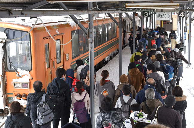 津軽五所川原駅でストーブ列車に乗り込む乗客